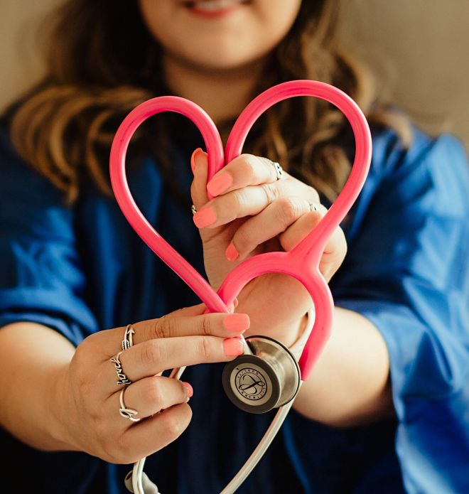 Doctor holding a stethiscope in the shape of a heart.