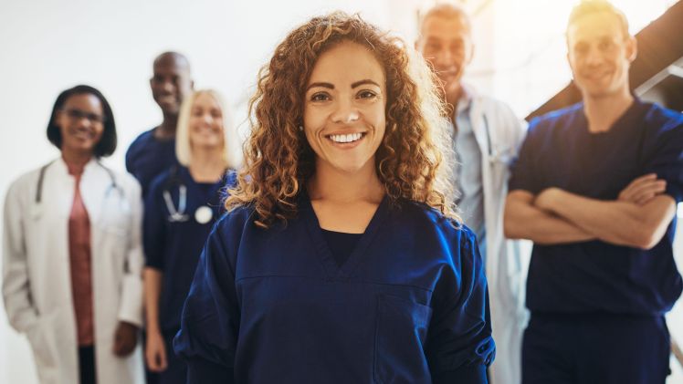 Smiling female doctor standing with medical colleagues in a hospital