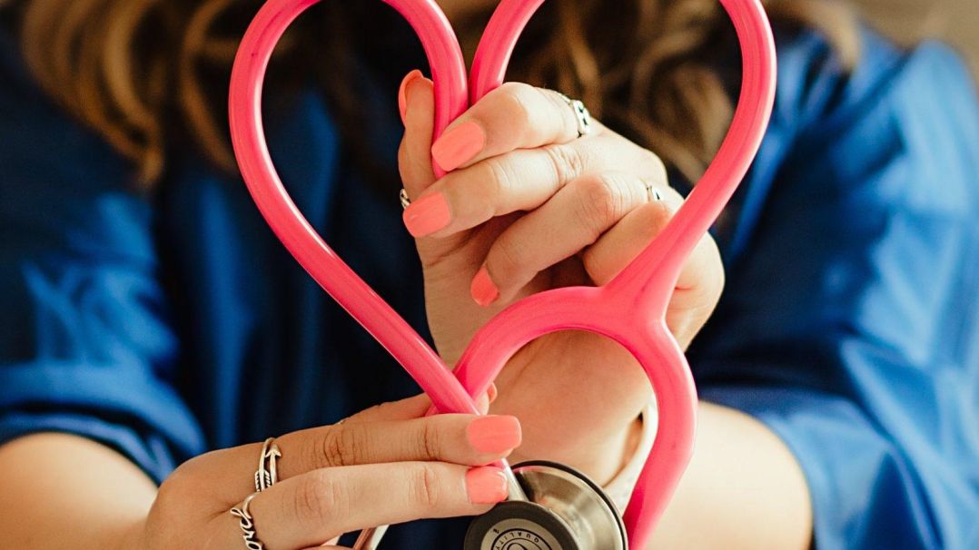 Doctor holding a stethiscope in the shape of a heart.